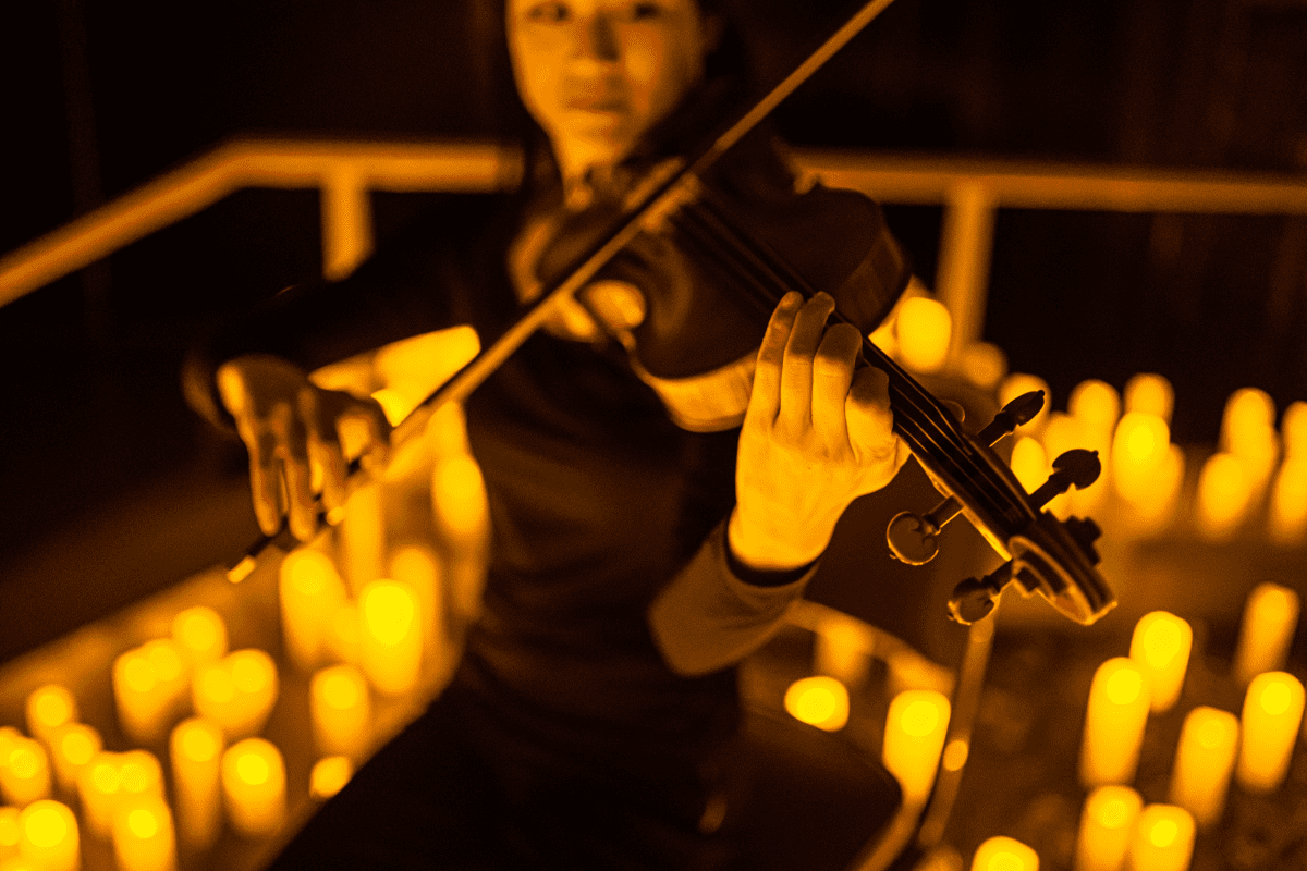 Una donna che suona il violino durante un concerto di Candlelight.